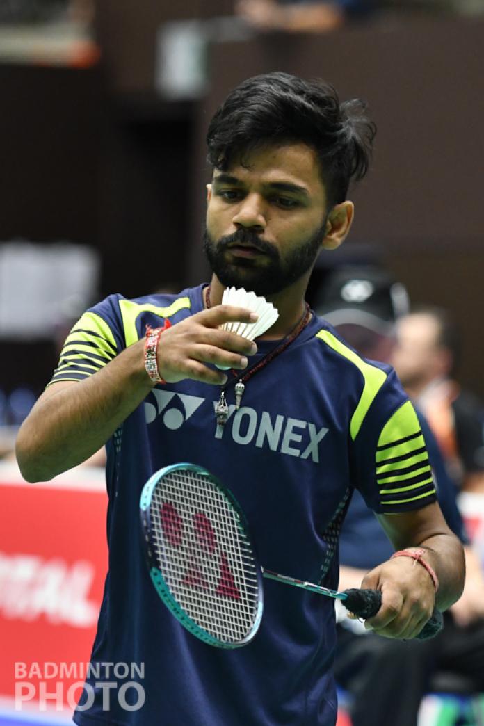 Short statured Indian man prepares to serve the shuttle