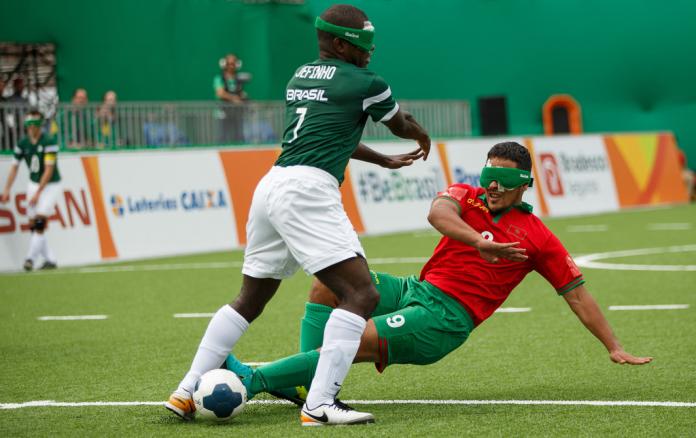 Man slides to take ball away from opponent