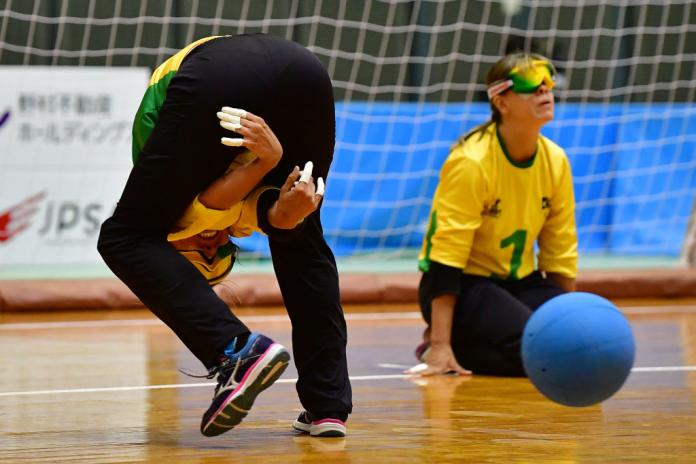 Woman throws goalball between legs