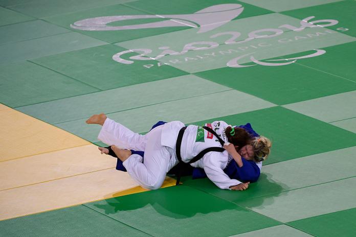 Two female judo fall on the mat 