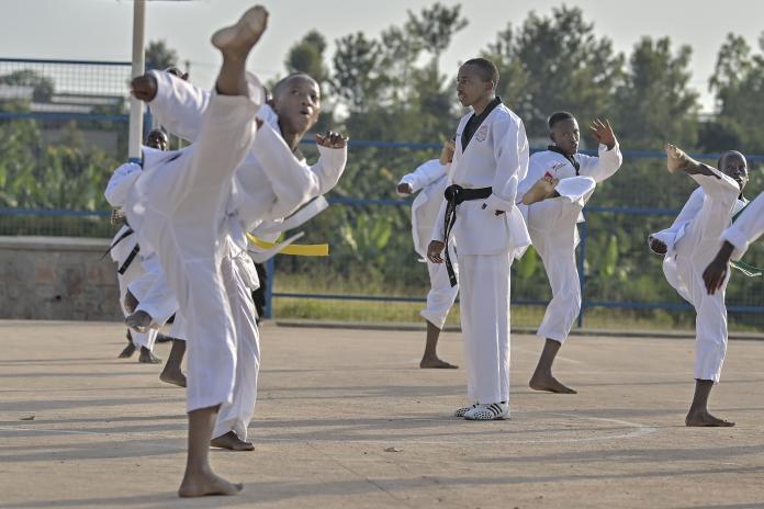 Parfait Hakizimana surrounded by his students at his taekwondo academy