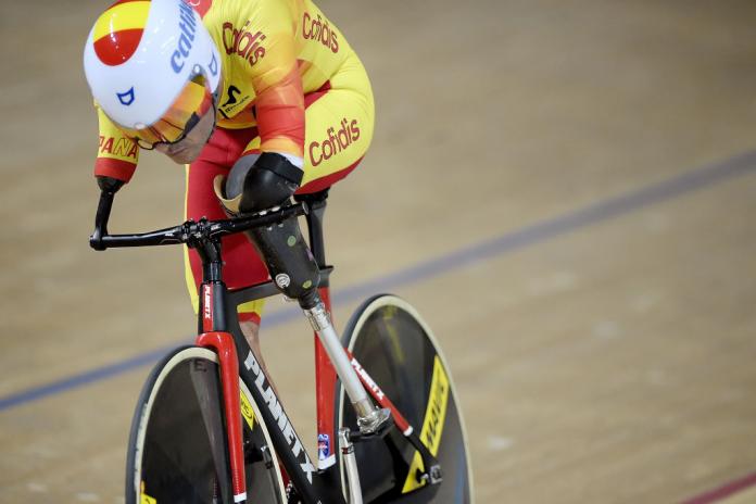 Man with no arms riding bike in velodrome