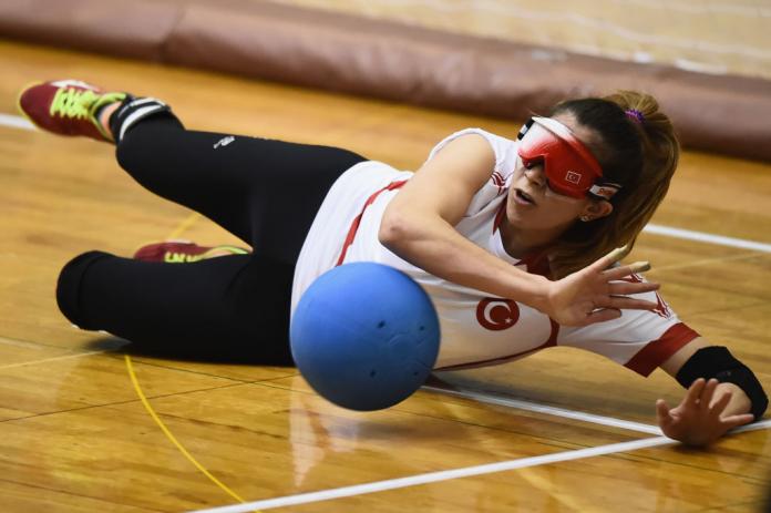 A goalball player dives to stop the ball