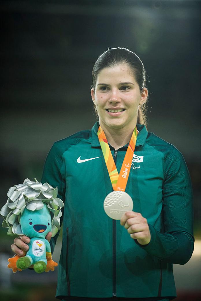 Female judoka smiles with medal and Rio 2016 mascot