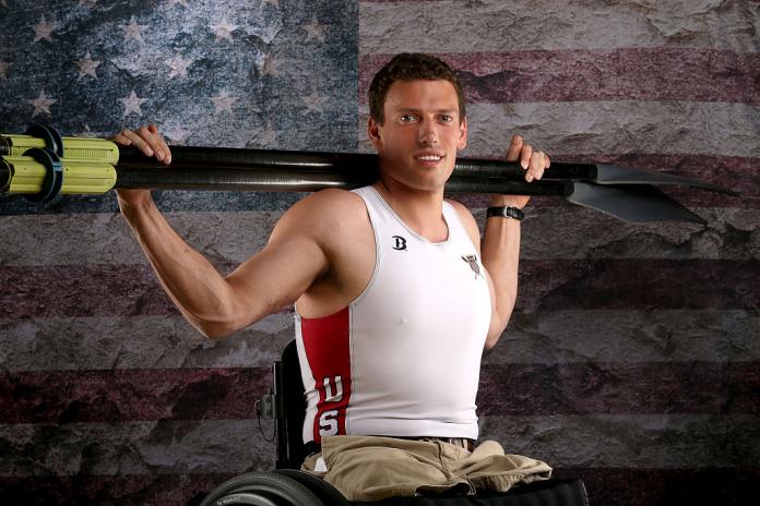 Man poses for portrait with oars on shoulders