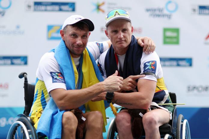 Two male rowers pose together for a picture