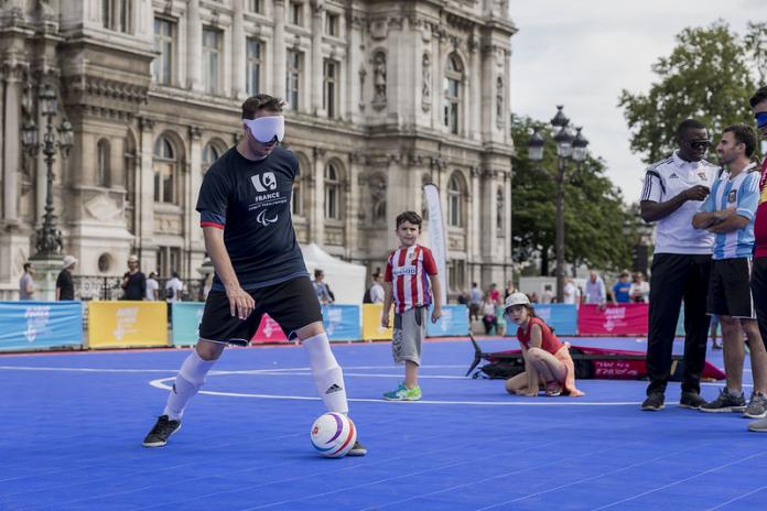 Man with blindfold dribbles soccer ball