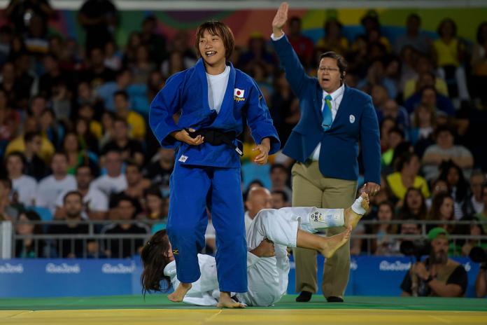 Japanese female judoka celebrates after taking down her opponent on the mat