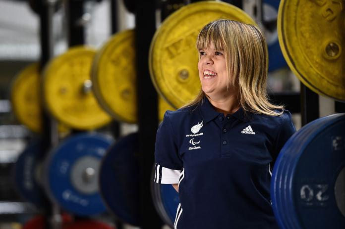 Women powerlifting smiling off to the side during a photoshoot