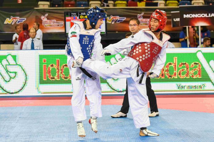 Man kicks his opponent in taekwondo