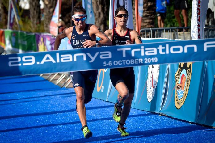 Two women do a sprint finish toward the finish line in triathlon