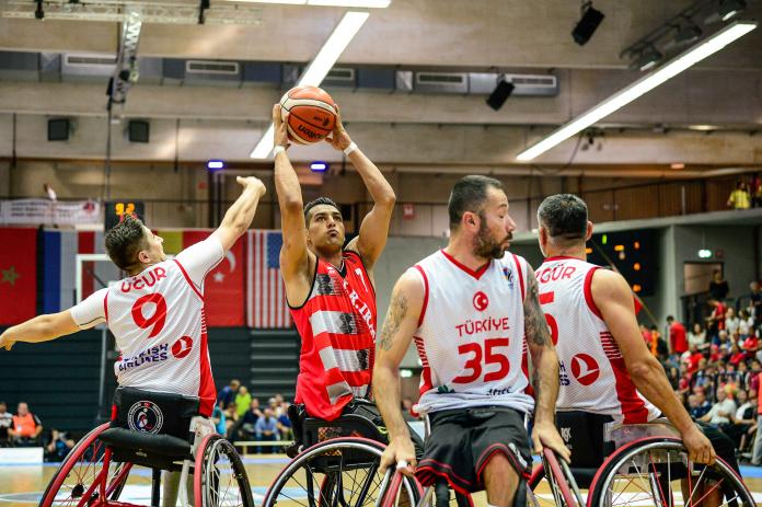 Iranian wheelchair basketball player Omid Hadiazhar is defended by Turkish player