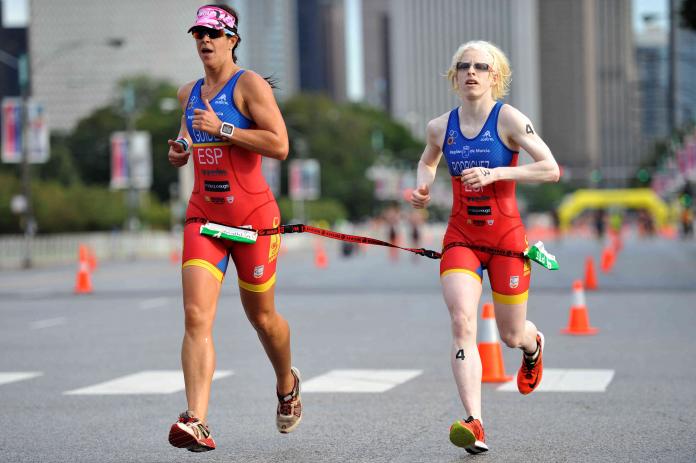 Visually impaired triathlete strapped to her guide while running