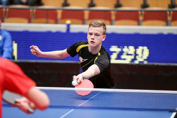 Male table tennis player hits a return shot