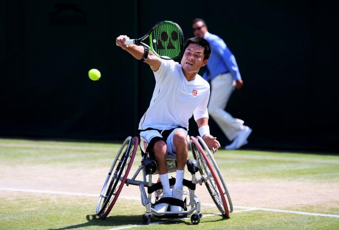 Japanese male wheelchair tennis player does backhand return