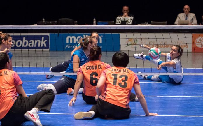 Woman reaches to save the volleyball