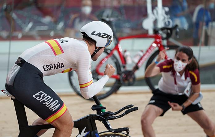 Man on track cycle celebrates with his coach on the side