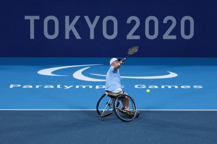 Steven Olsson plays a shot in front of Tokyo 2020 logo