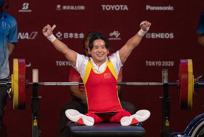 Guo Lingling celebrates on the bench after setting a new world record