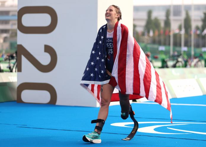 Female triathlon with USA flag wrapped around her