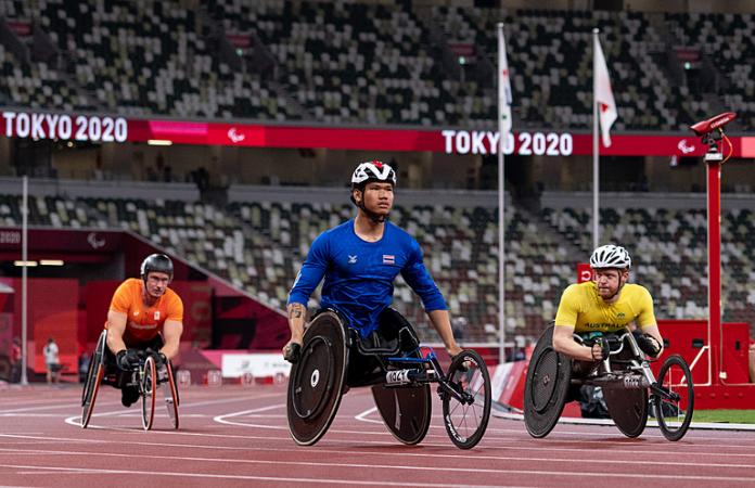 Thai wheelchair racer Athiwat Paeng-Nuea on the track followed by an Australian and a Dutch racers