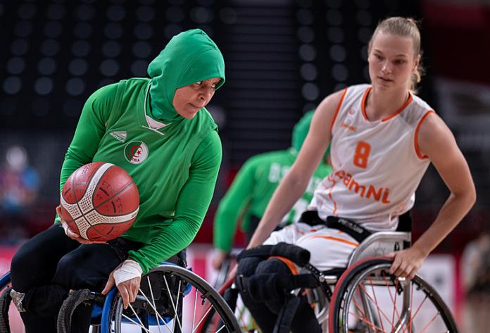 Algerian wheelchair basketball female athlete tries to dribble around her opponent