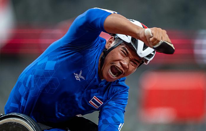Thai wheelchair racer Pongsakorn Paeyo celebrates after crossing the finish line