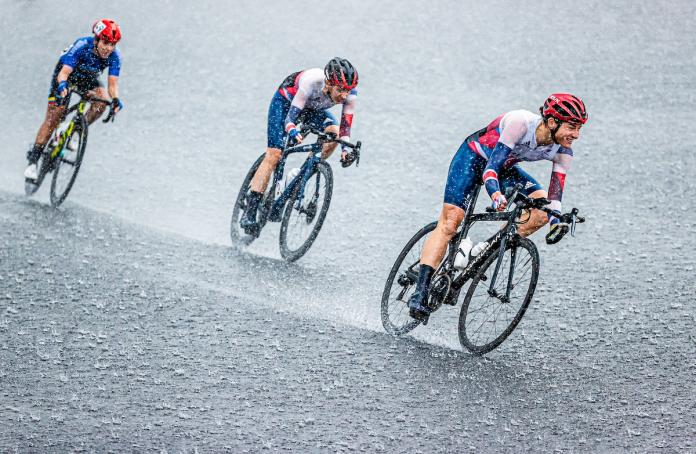 Pengendara sepeda menghadapi hujan lebat dalam lomba jalan raya