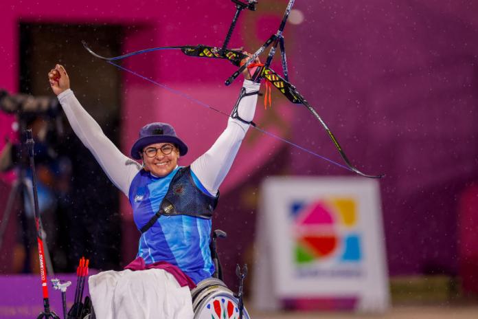 Female archer raises arms in triumph
