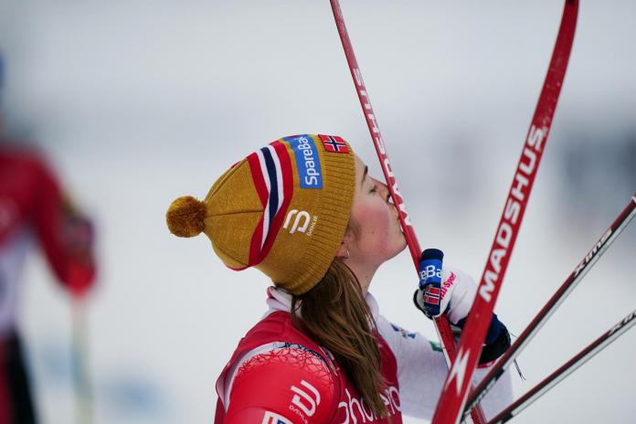 A female skier kissing her skis 