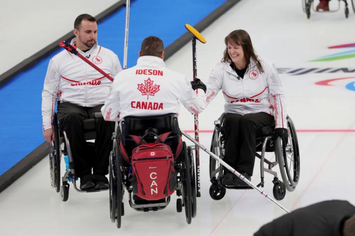 The Canadian curling team celebrate after winning one of their opening matches