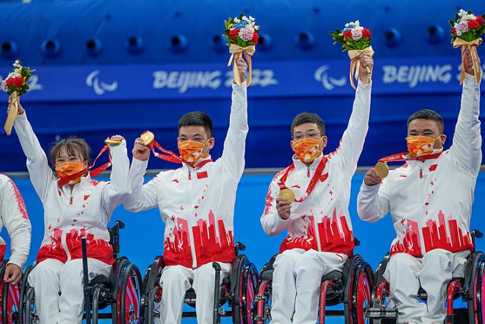 Chinese wheelchair curlers hold their gold medals in the air
