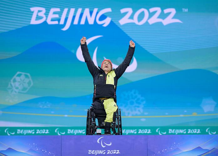 Anna-Lena Forster reaches up to the sky and shouts in delight during her medal ceremony