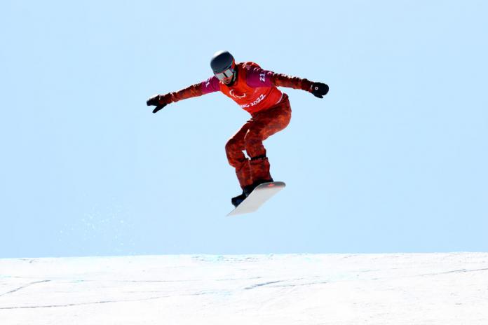 A male Para snowboarder in boardcross competition