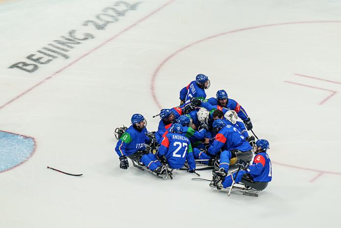 The Italian ice hockey team pile on top of Nils Larch after he scores the winning goal in sudden death