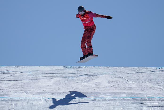 Tyler Turner gets air as he races down the Para snowboard course at Beijing 2022