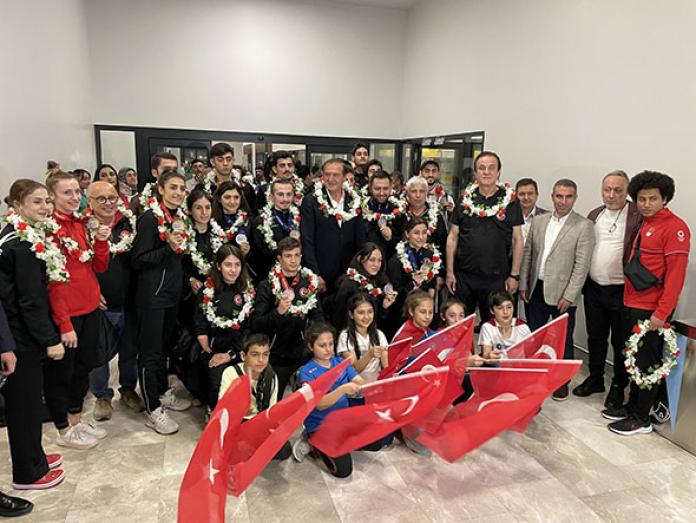 Turkish athletes pose for a group photo with the national flags.