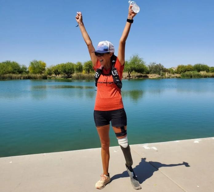 Jacky Hunt-Broersma celebrates with her hands raised after finishing 102 marathons in 102 consecutive days and setting a Guinness world record.