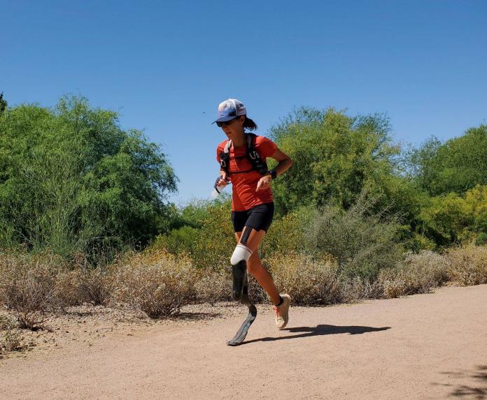 Jacky Hunt-Broersma runs along a sandy trail in Arizona with her left leg attached to a running blade.