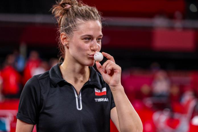 Natalia Partyka smiles as she kisses a table tennis ball after winning a gold medal in the women's team class 9-10 event at Tokyo 2020.