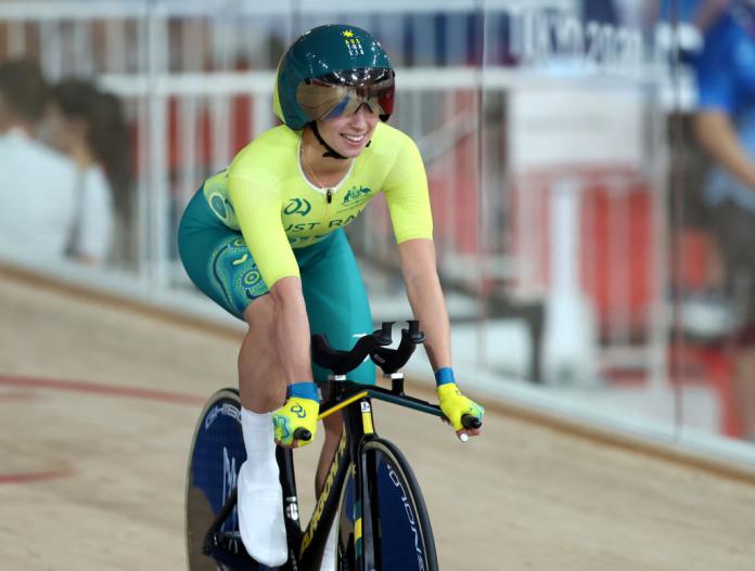Paige Greco smiles as she casually pedals on the track of the Izu Velodrome at the Tokyo 2020 Paralympic Games.