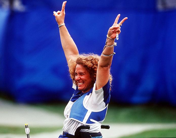 An female archer celebrating in her wheelchair.