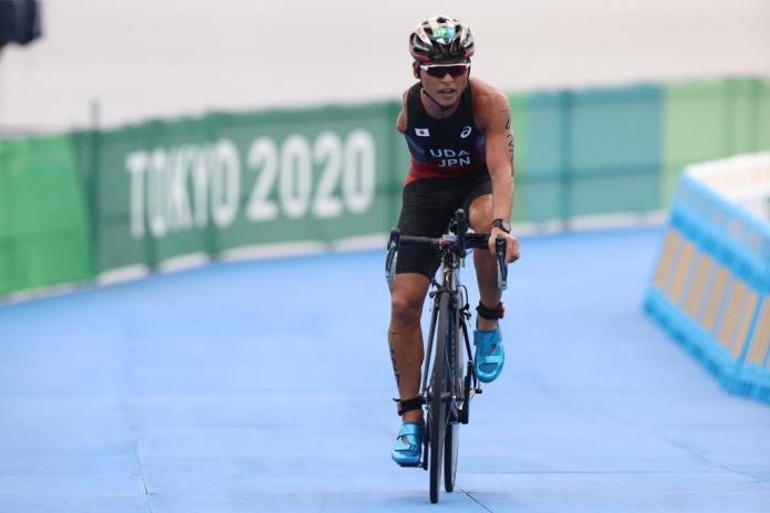 Japan's Uda Hideki pedals his bicycle between Tokyo 2020 banners in the second stage of his men's Para triathlon PTS4 race.