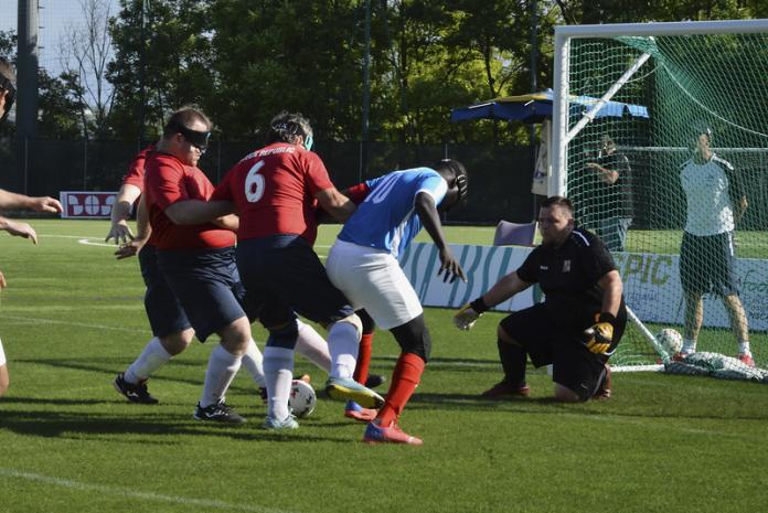 Image of male blind football players from France and Czech Republic in front of the Czech Republic goalkeeper