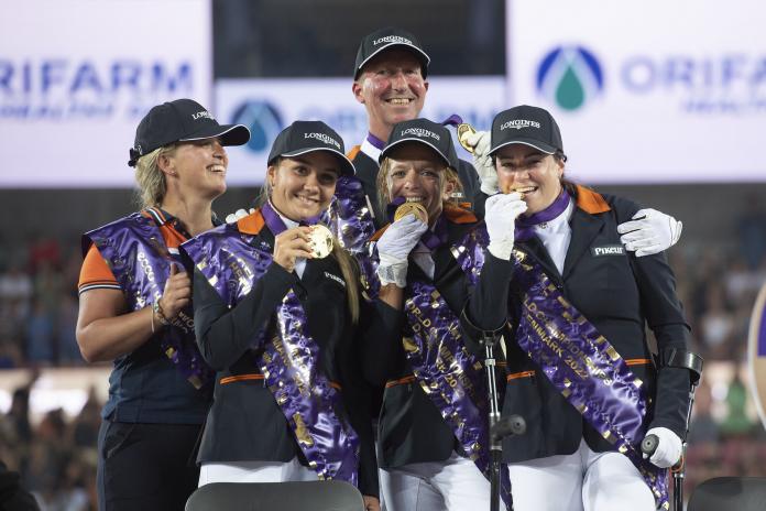 Five athletes raise their gold medals after winning the teams competition at the Para Dressage World Championships