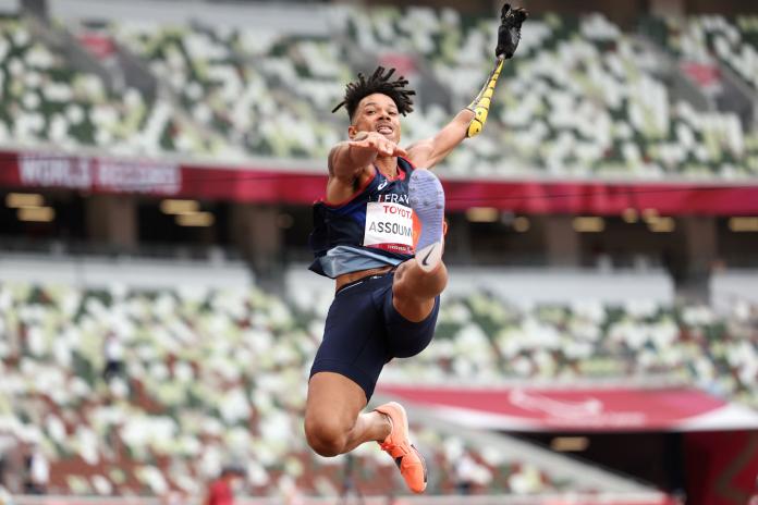 An athlete flies through the air during his long jump attempt.