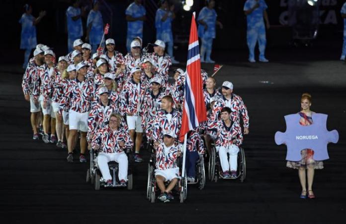 An athlete on a wheelchair, which has Norway's flag attached to it, leads about 30 members of his team into the Opening Ceremony of the Rio 2016 Summer Paralympic Games.