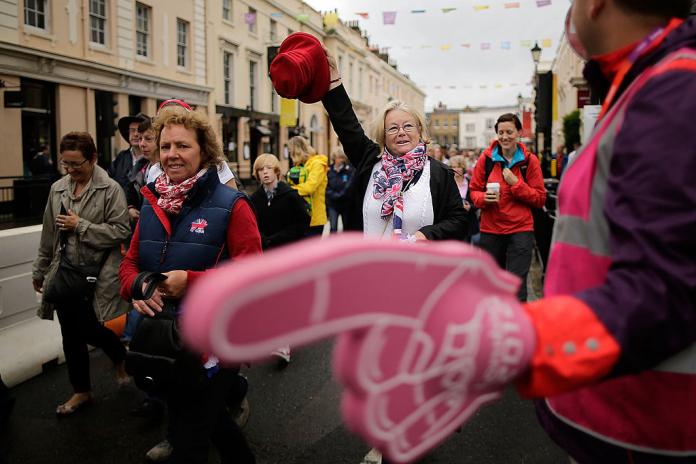 A volunteer with a large pink glove directs spectators at the London 2012 Games.
