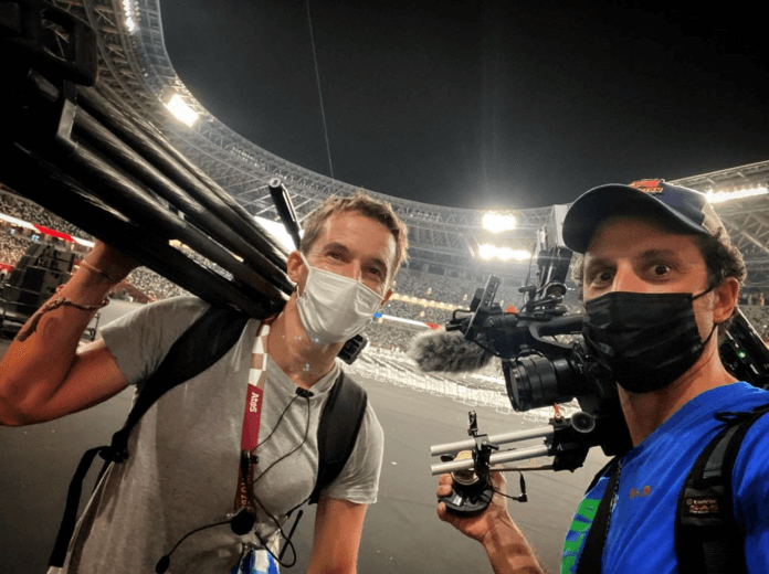 Two men hold filming equipment at a venue of the Tokyo 2020 Paralympic Games.