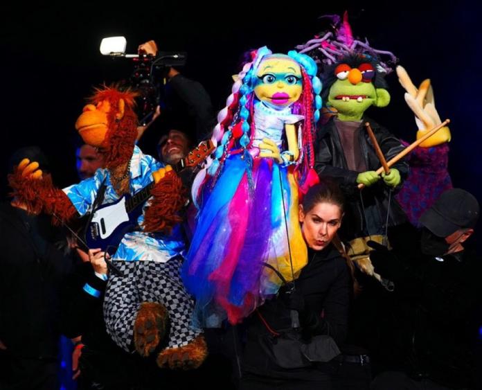 Puppets and puppet masters in a middle of a performance.